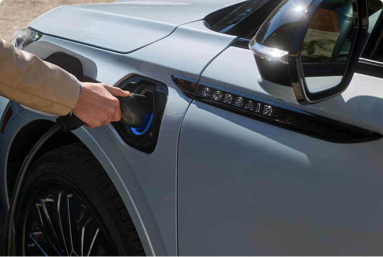 A person inserts the Lincoln Mobile Power Cord into the charging port of a Lincoln Corsair® Grand Touring Plug-In Hybrid SUV