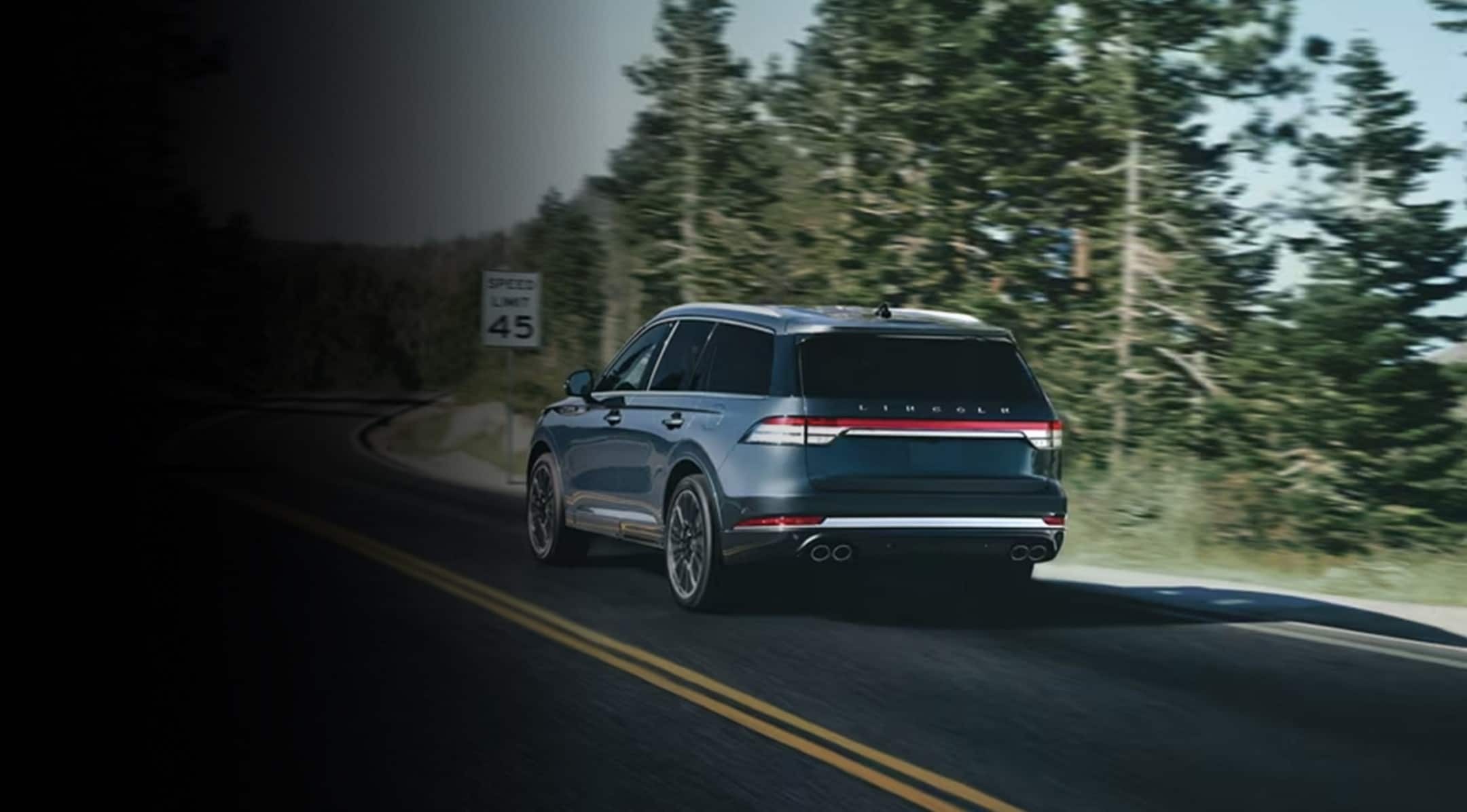 A 2024 Lincoln Aviator® SUV is being driven along a winding road