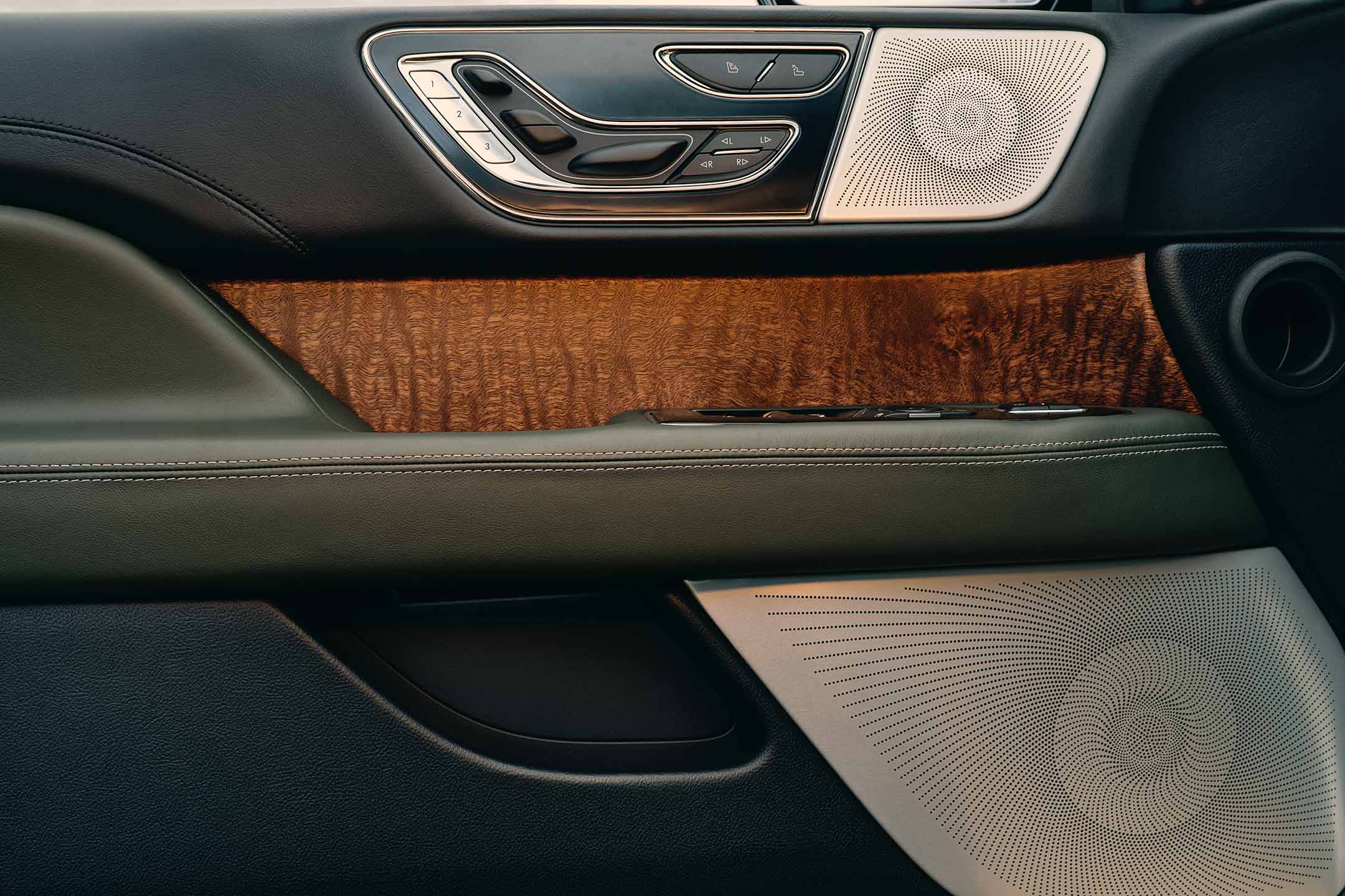 El panel de la puerta de una SUV Lincoln Black Label Navigator® 2024 muestra un collage de formas geométricas y texturas elegantes.
