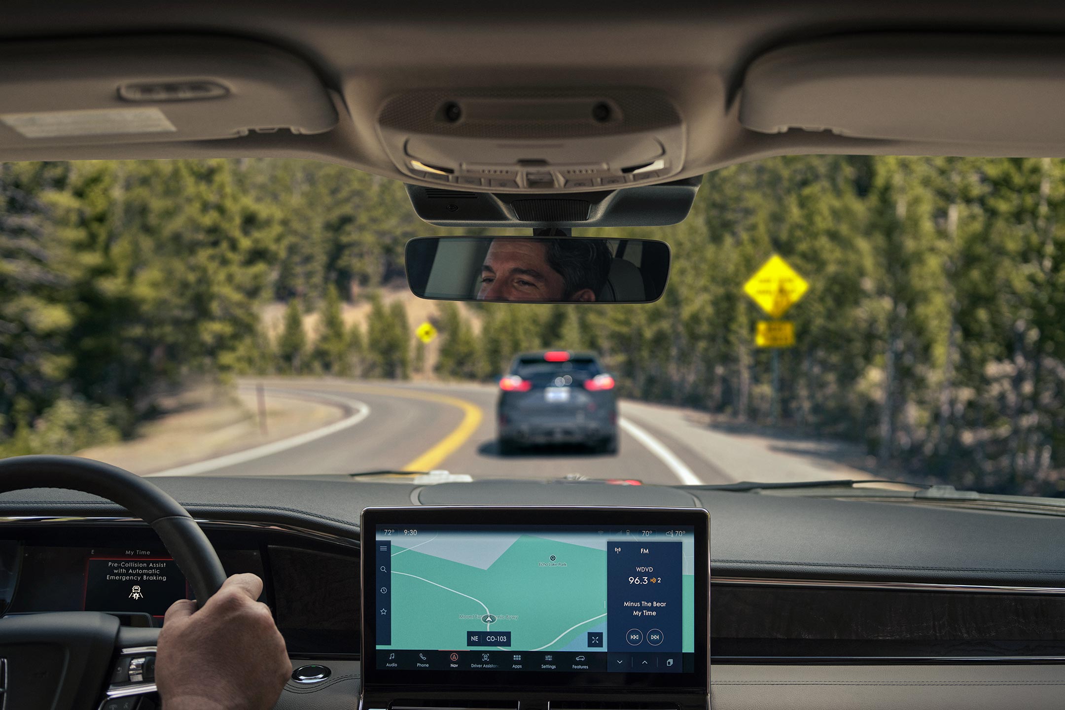 A través del parabrisas de una SUV Lincoln Navigator® 2024, se ve un auto adelante que frena.